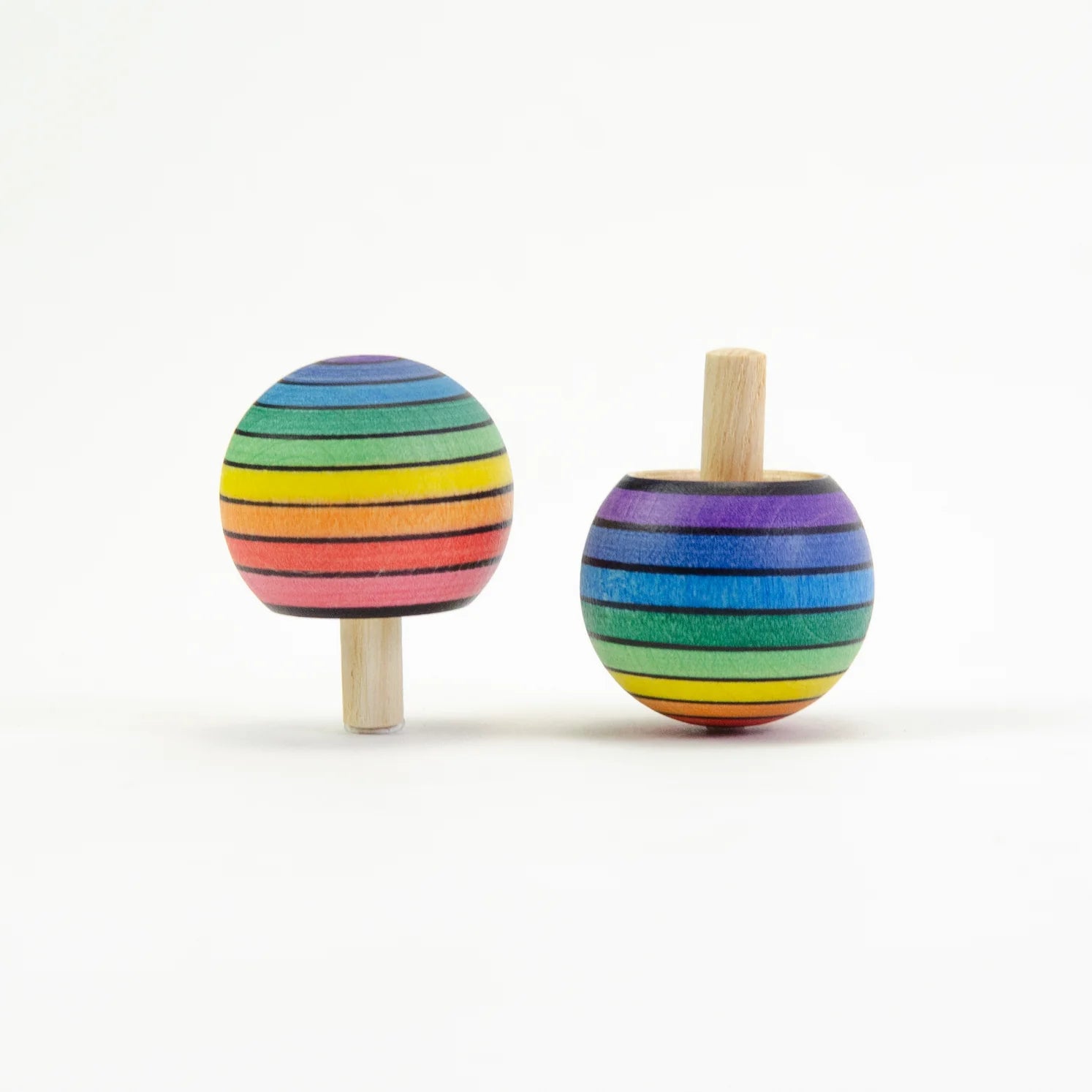 Two rainbow-striped wooden toys on sticks against a white background