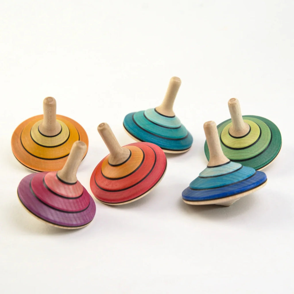 Set of colorful wooden spinning tops on a white background