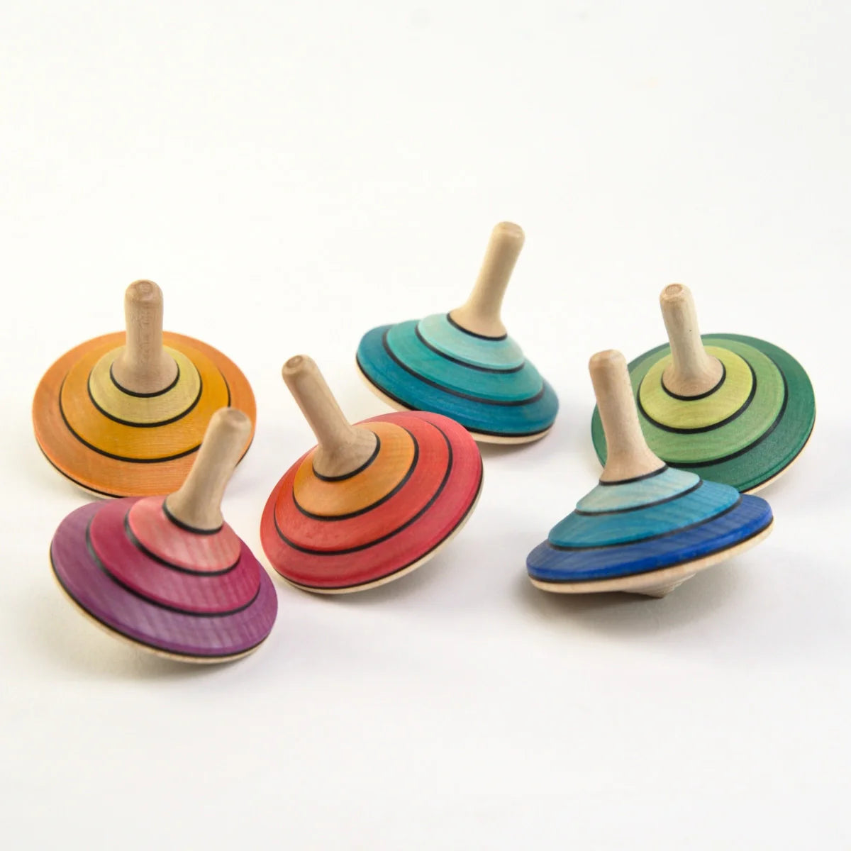 Set of colorful wooden spinning tops on a white background