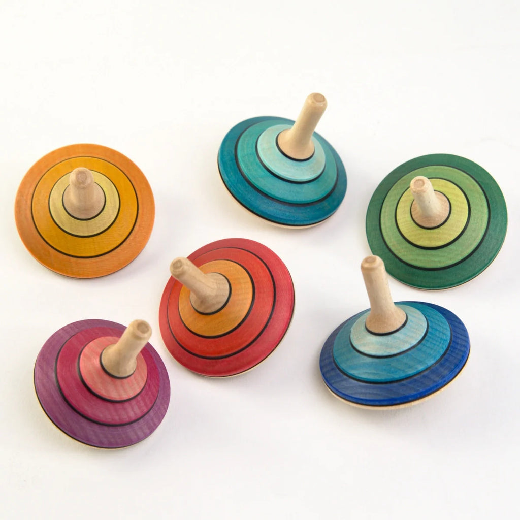 Set of colorful wooden spinning tops on a white background