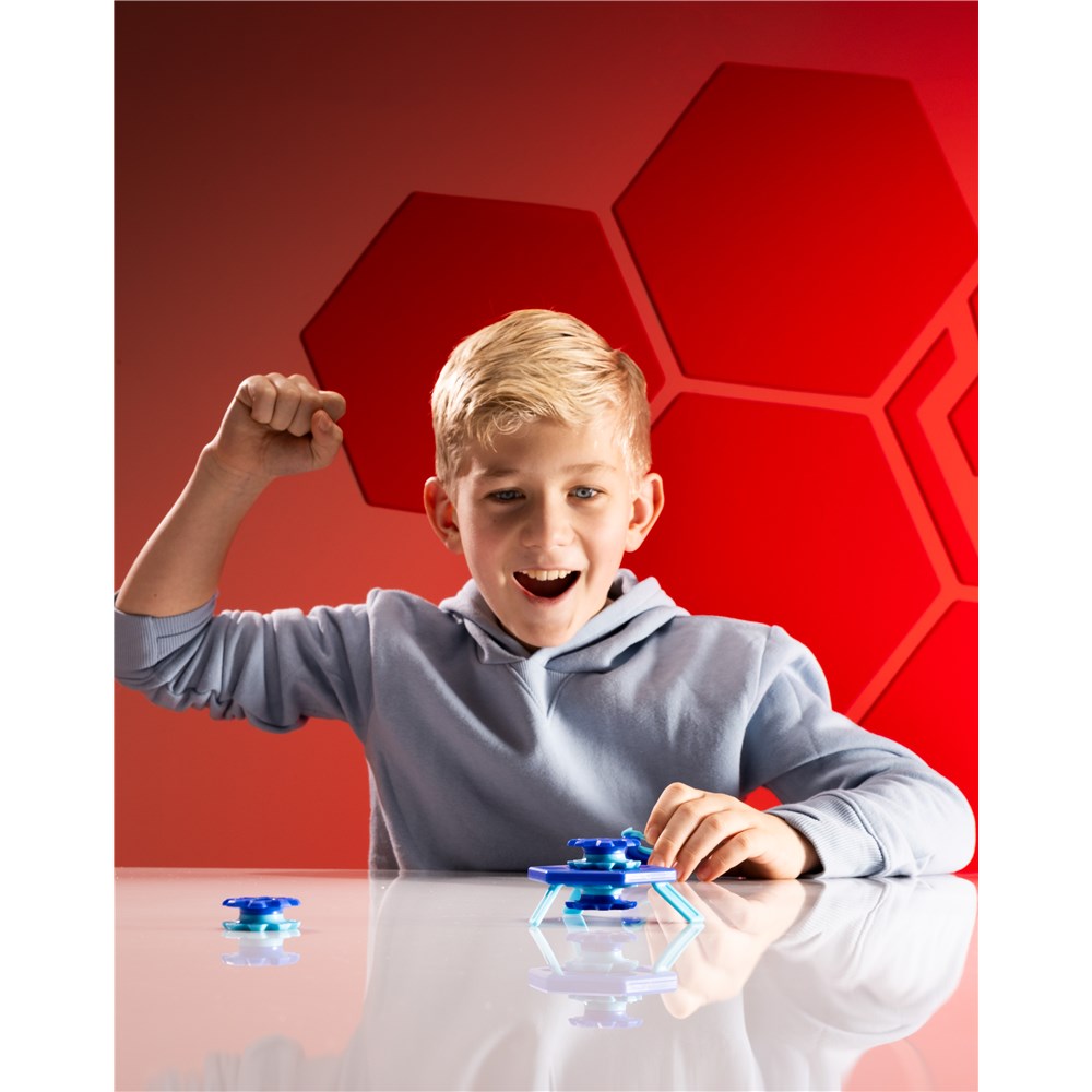 Child playing with a fidget spinner against a red geometric background