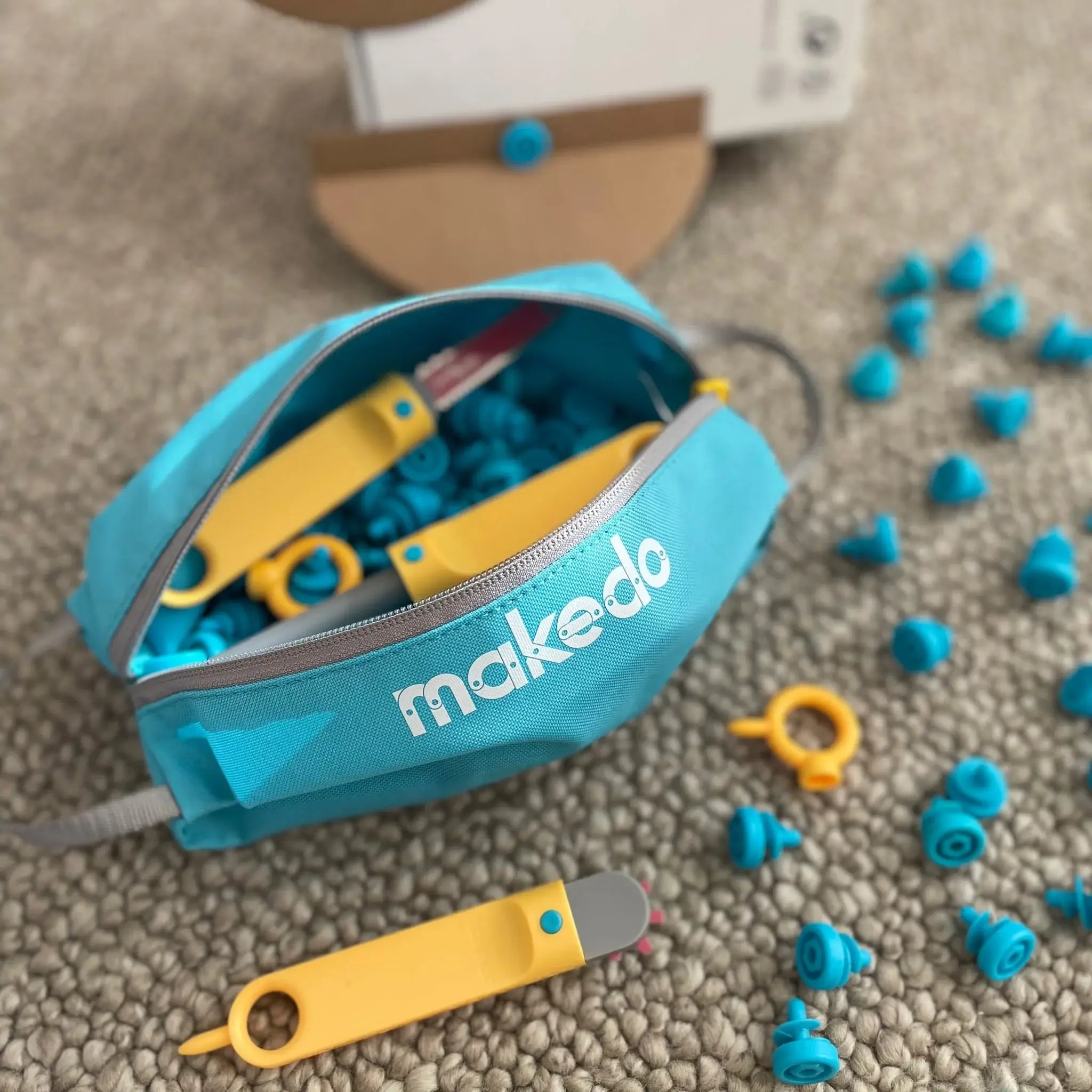 Makedo construction set with tools and components on a textured surface