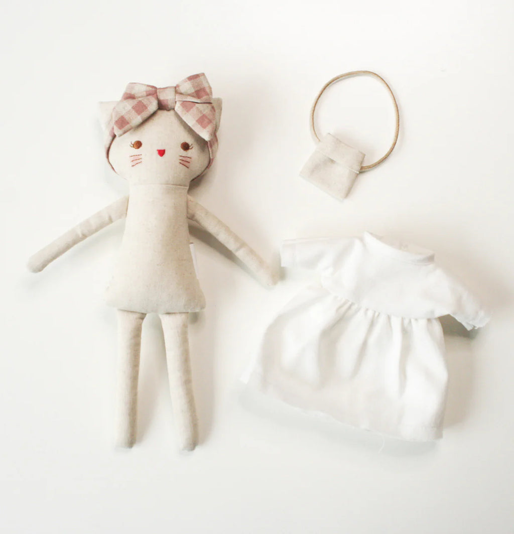 Fabric doll kitten with a checkered bow and a matching dress on a white background.
