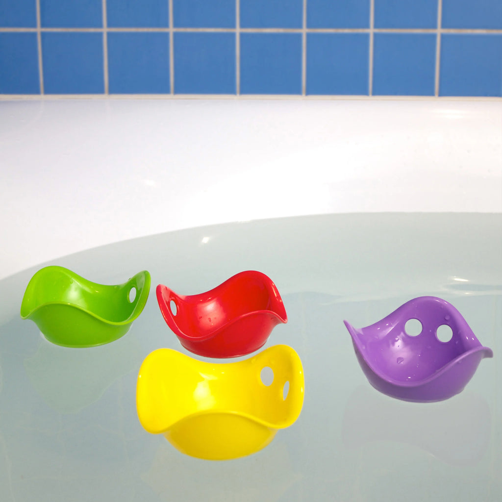 Four colorful bird-shaped cups on a bathtub with a blue tiled wall background.