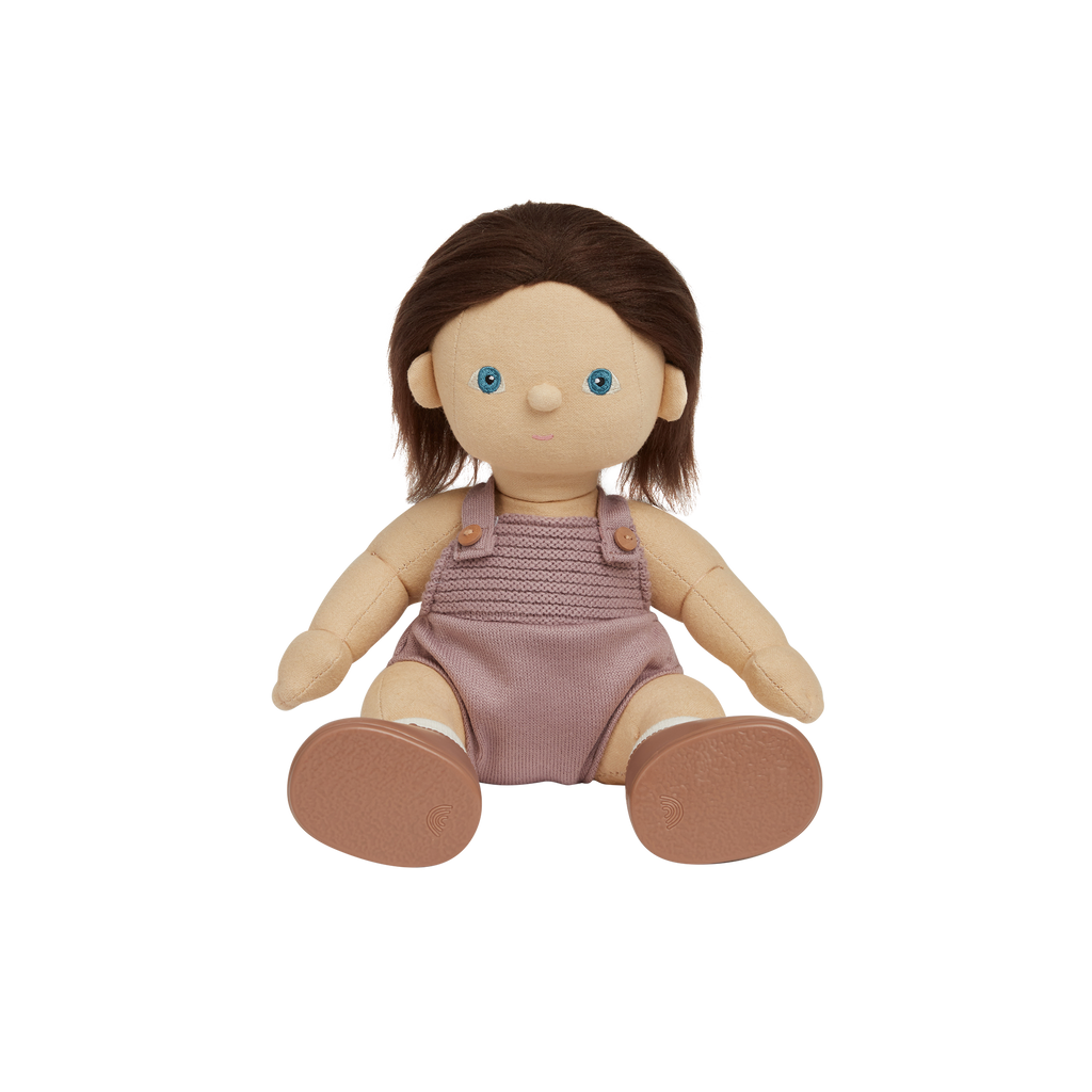 Doll with brown hair and blue eyes wearing a pink knitted romper on a white background