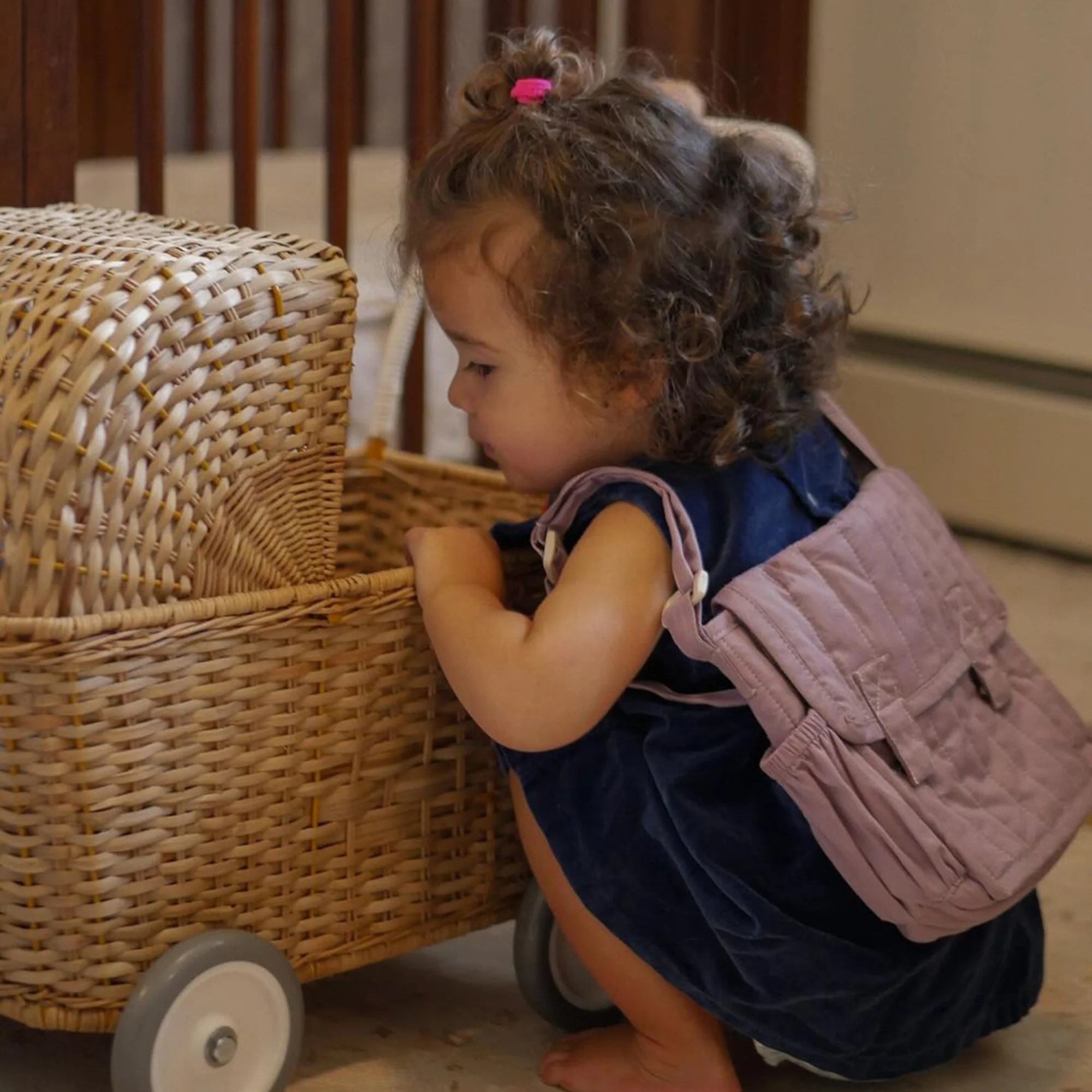 Child playing with a wicker toy chest in a home setting