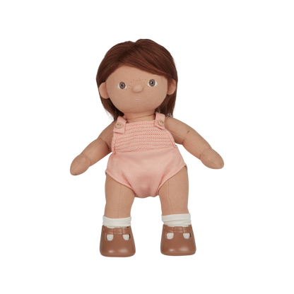 Doll with brown hair wearing a pink romper on a white background