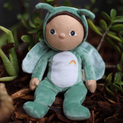 Plush toy dressed as a grasshopper with a rainbow on a natural background