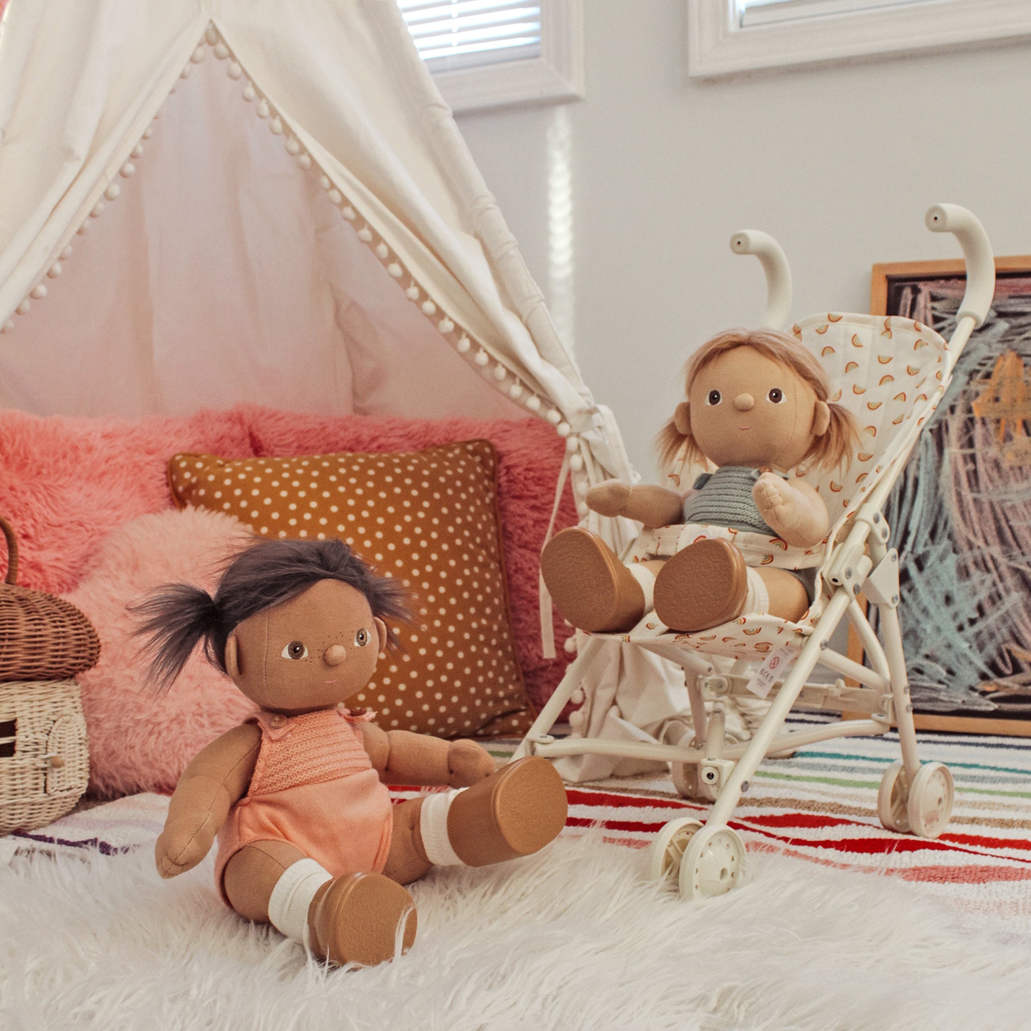 Two dolls in a child's bedroom with a canopy bed and colorful pillows.