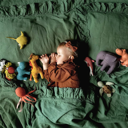 Child sleeping in bed with plush animals