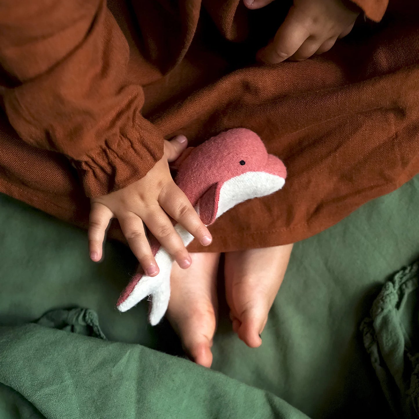 Child holding pink dolphin 
