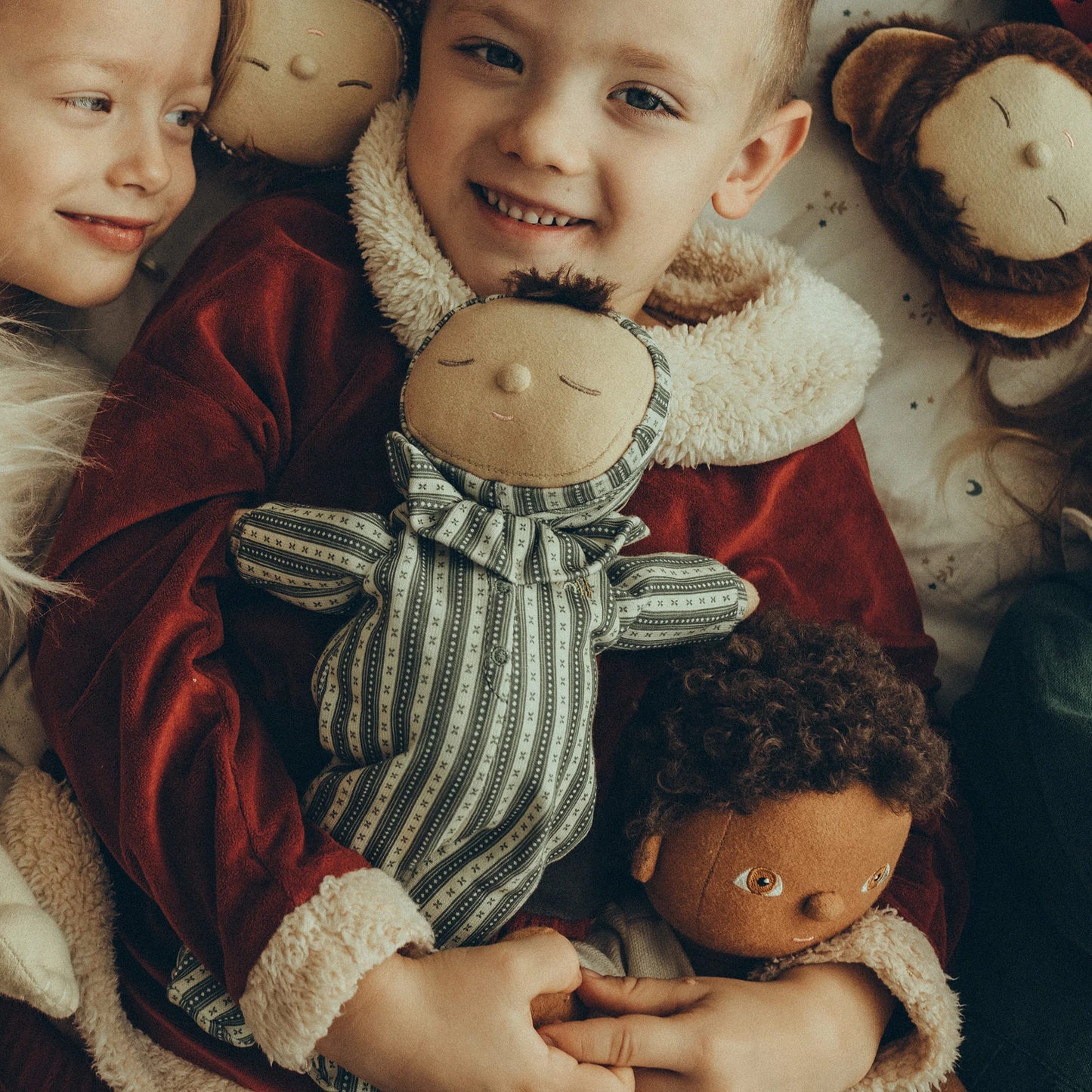 Children holding dolls with a warm and cozy atmosphere