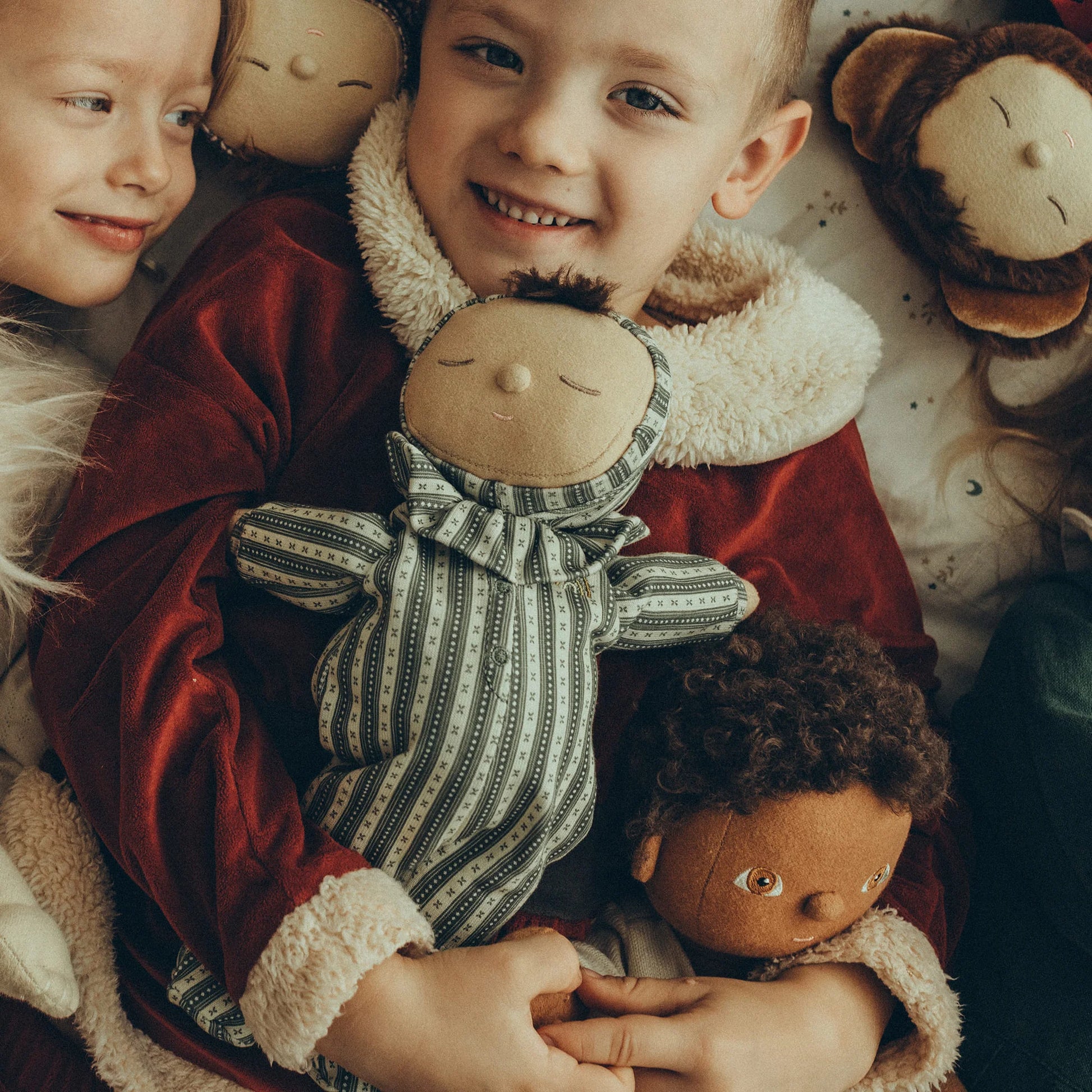Children holding dolls with a warm and cozy atmosphere
