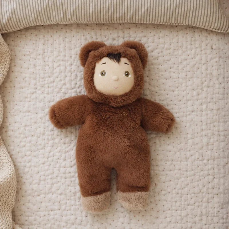 Stuffed toy in a brown bear costume on a textured beige surface