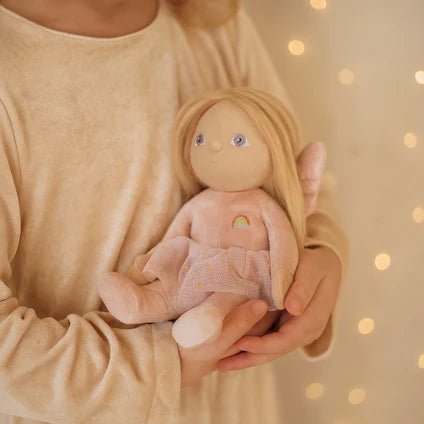 Person holding a soft toy with a blurred background of lights