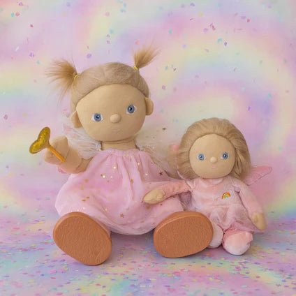 Two dolls with blonde hair and pink outfits on a colorful, rainbow-patterned background.