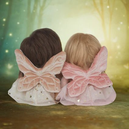 Two children wearing fairy wings against a glowing forest background