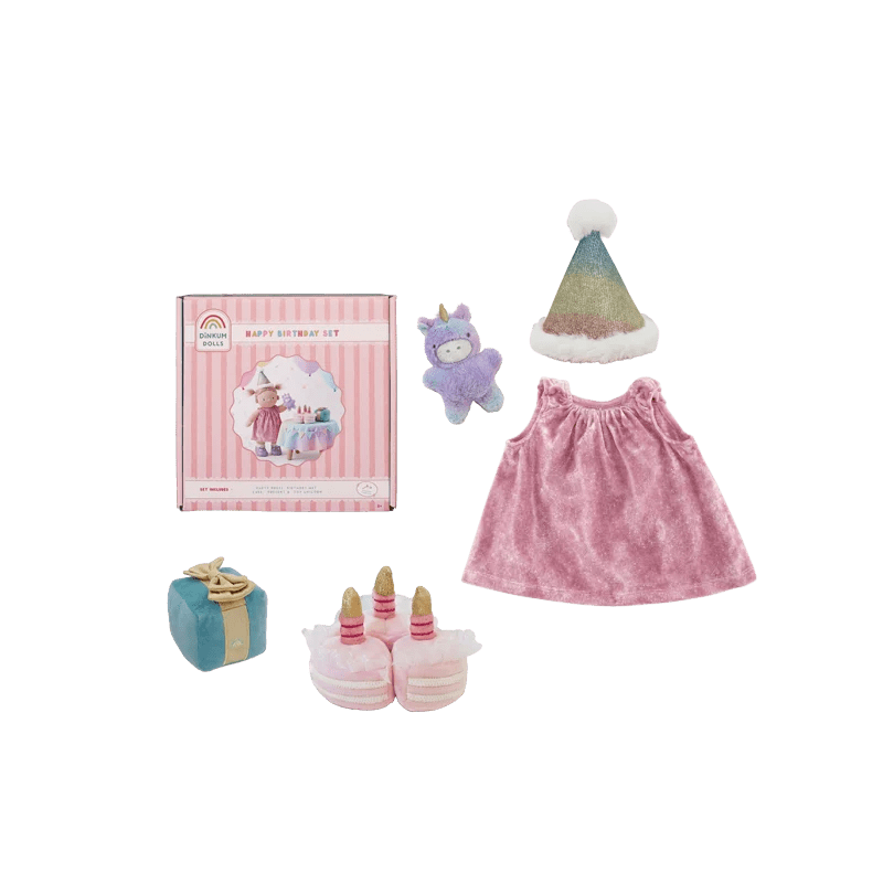 A doll birthday outfit set from Rainbow Rich Children's featuring a pink dress, a unicorn plush, a party hat, a small gift box, and a cake topper, displayed alongside its pink striped packaging box on a white background.