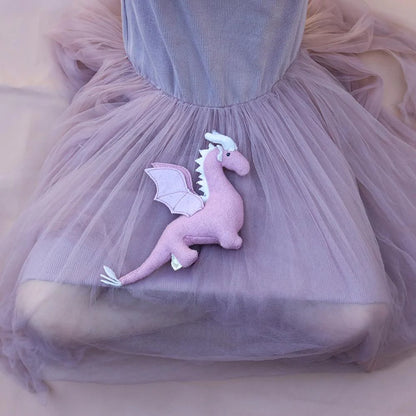 Pink dragon plush toy attached to a tulle skirt