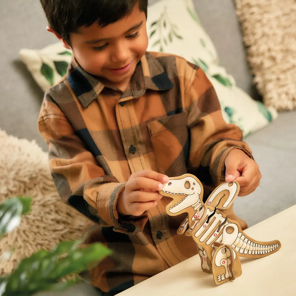 Child playing with a wooden dinosaur toy on a couch
