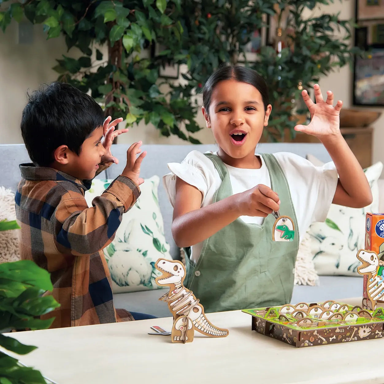 Two children playing with dinosaur game on a table in a home setting.