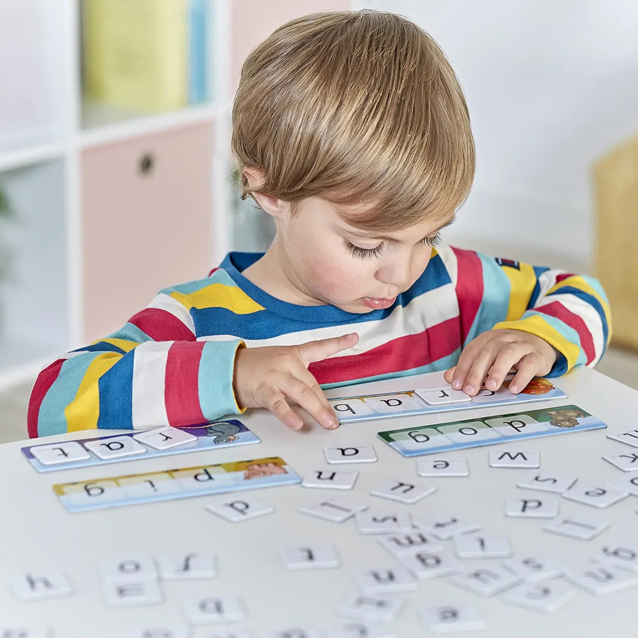 Child playing with alphabet letters on a table