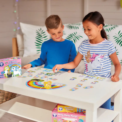 Two children playing with a board game at a table, surrounded by colorful game boxes.
