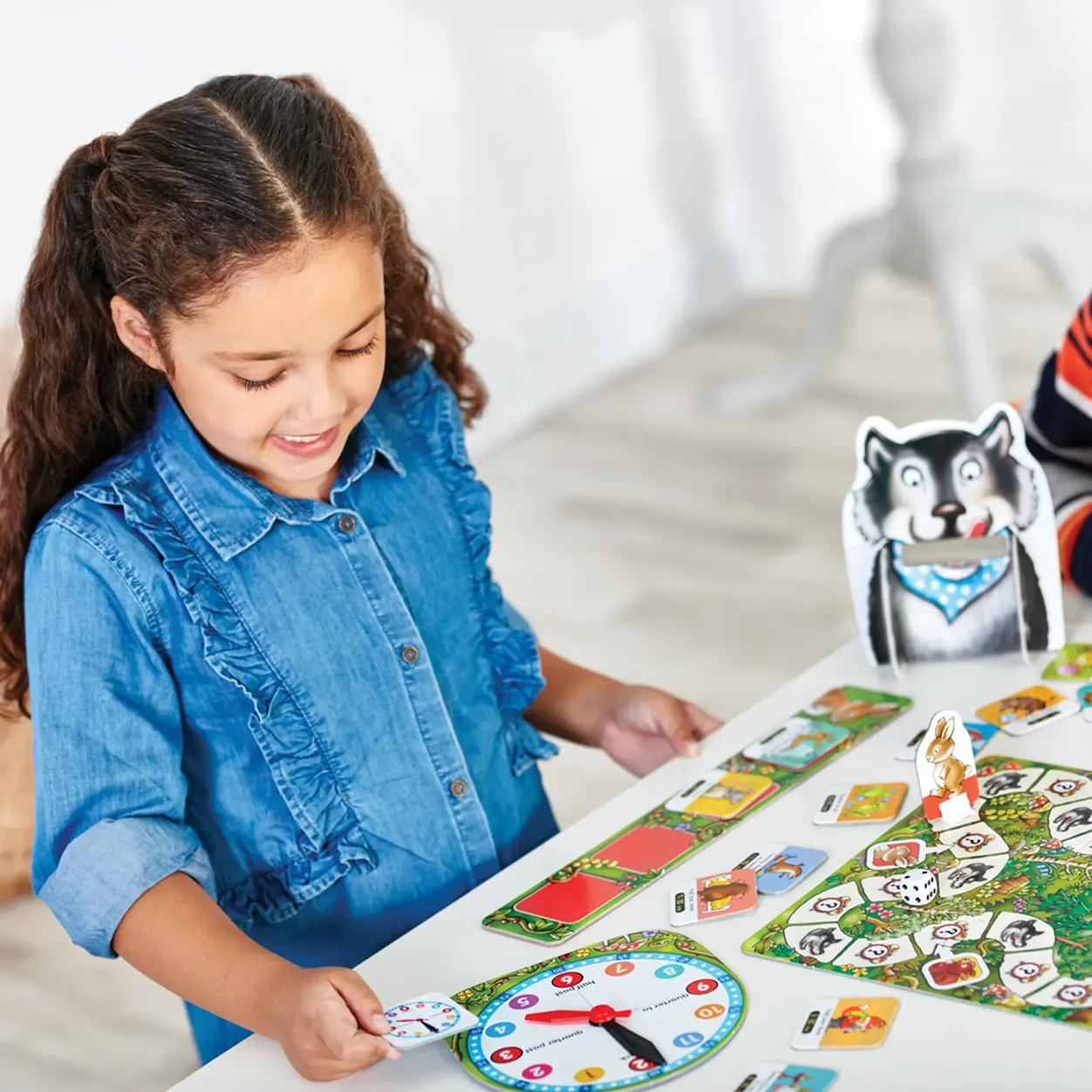 Child playing with a board game featuring animal cards