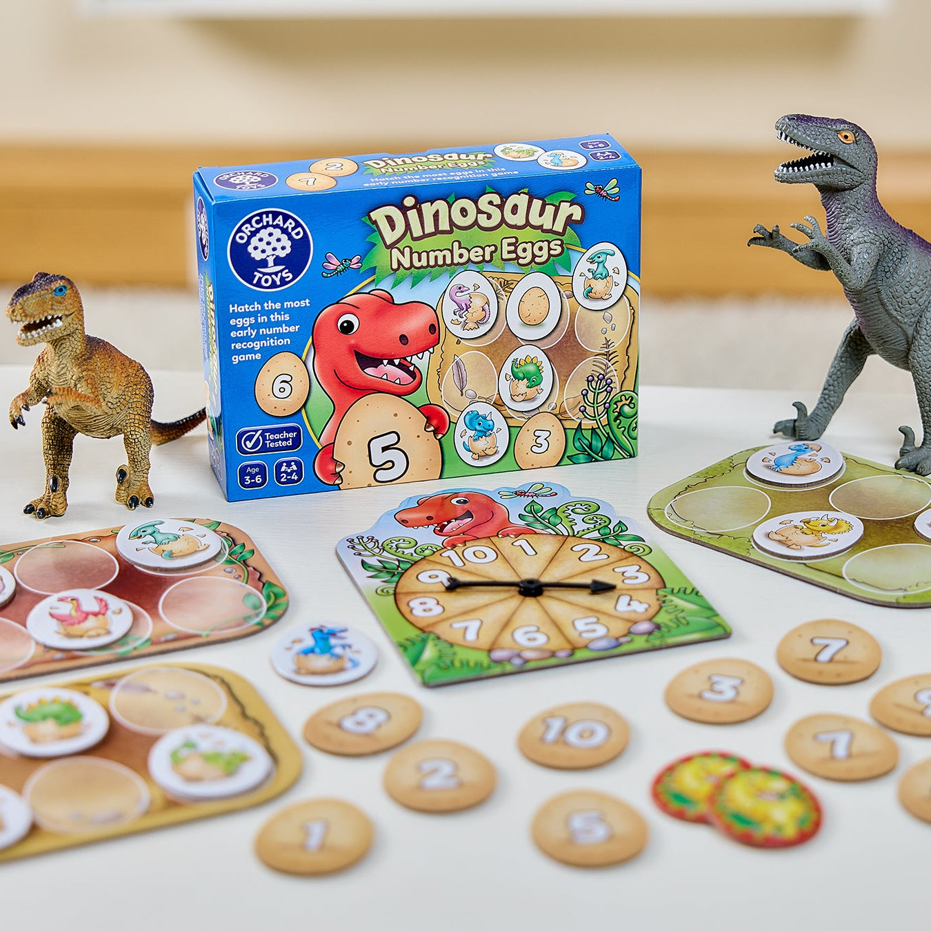 Dinosaur-themed educational game with toys and packaging on a table.