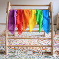 Colorful fabric on a wooden ladder against a white background