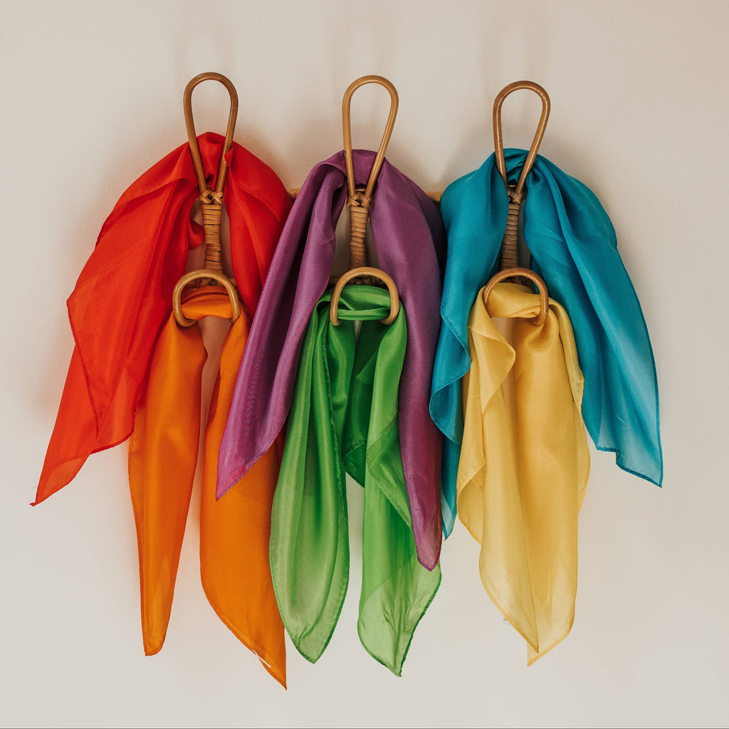 Set of colorful scarves hanging on a white background