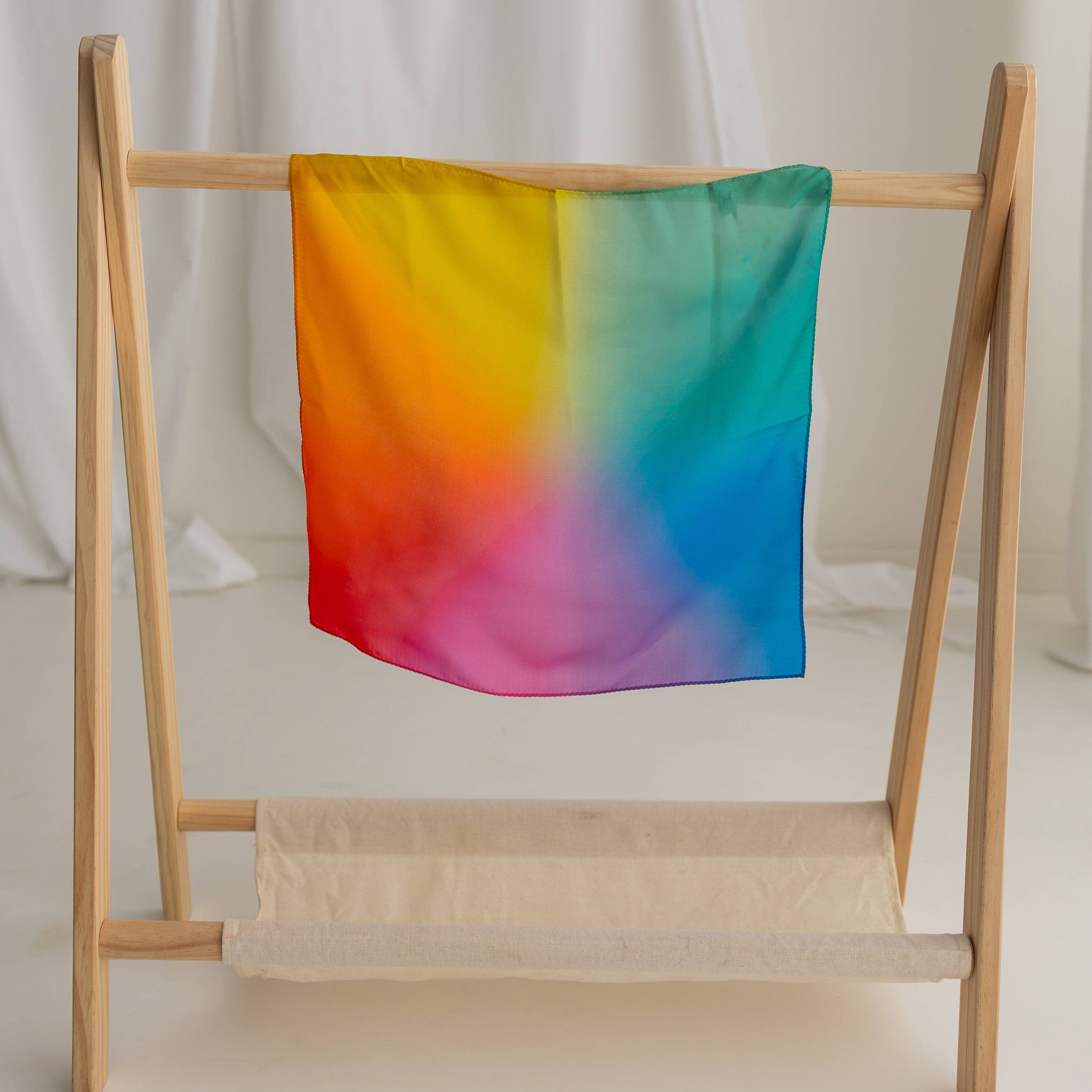 Colorful towel on a wooden rack against a white curtain background