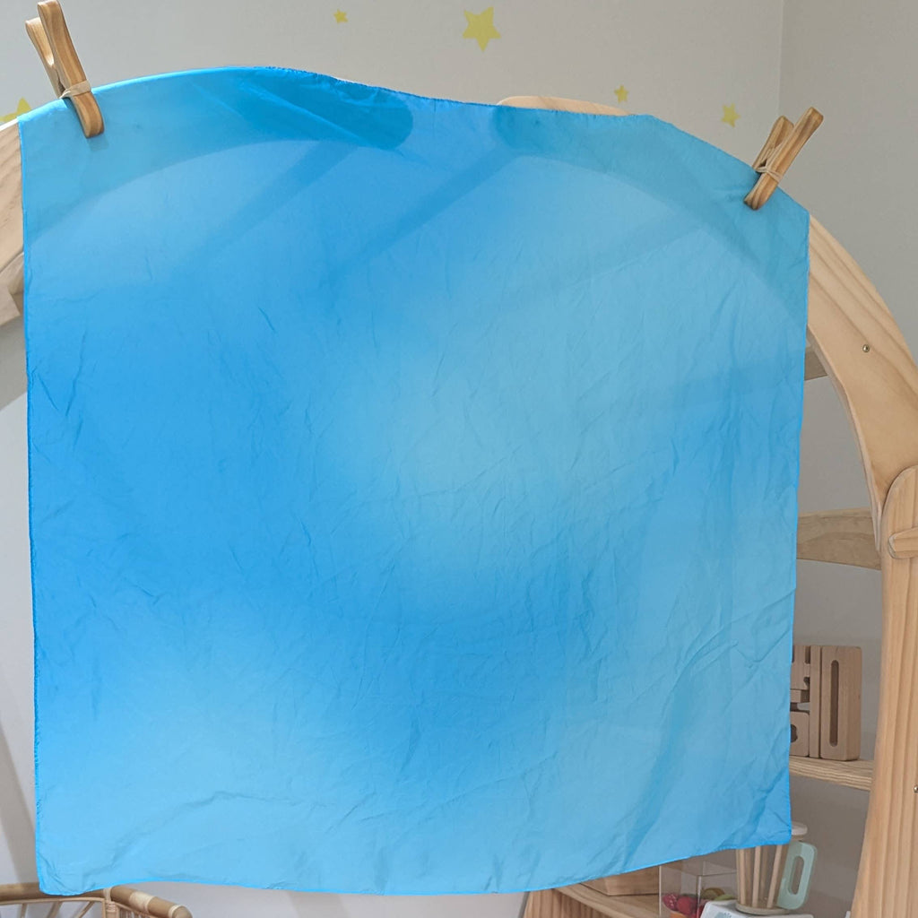 Children's playroom with a blue sheet on a wooden easel, colorful blocks, and toys.