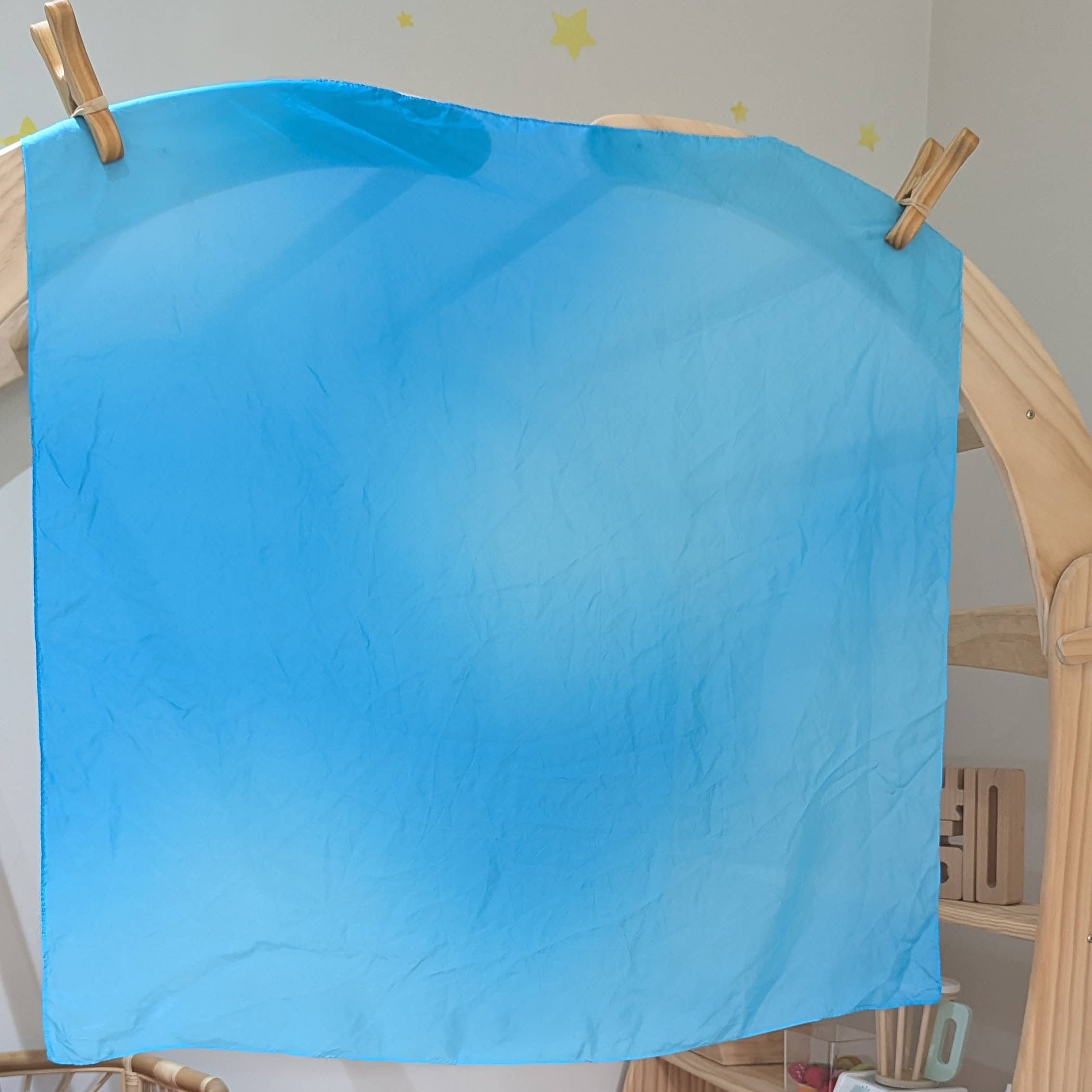 Children's playroom with a blue sheet on a wooden easel, colorful blocks, and toys.