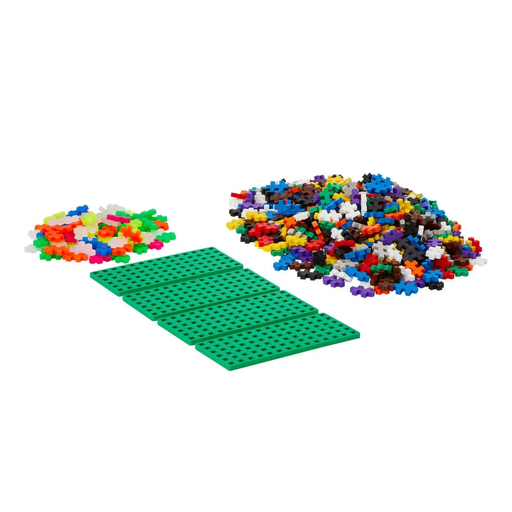 Colorful building blocks with a green baseplate on a white background