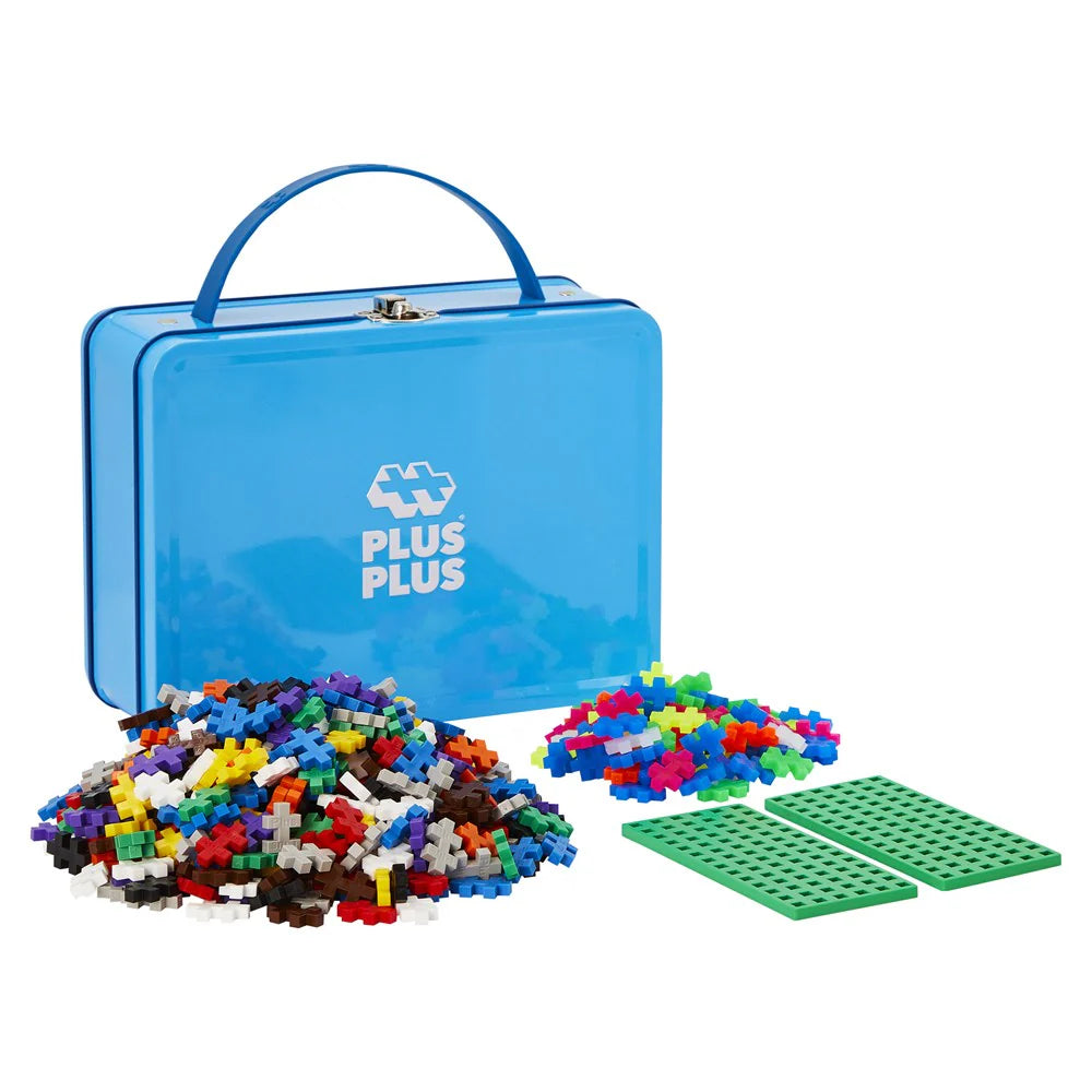 Blue storage box with Plus Plus building blocks and green baseplates on a white background.