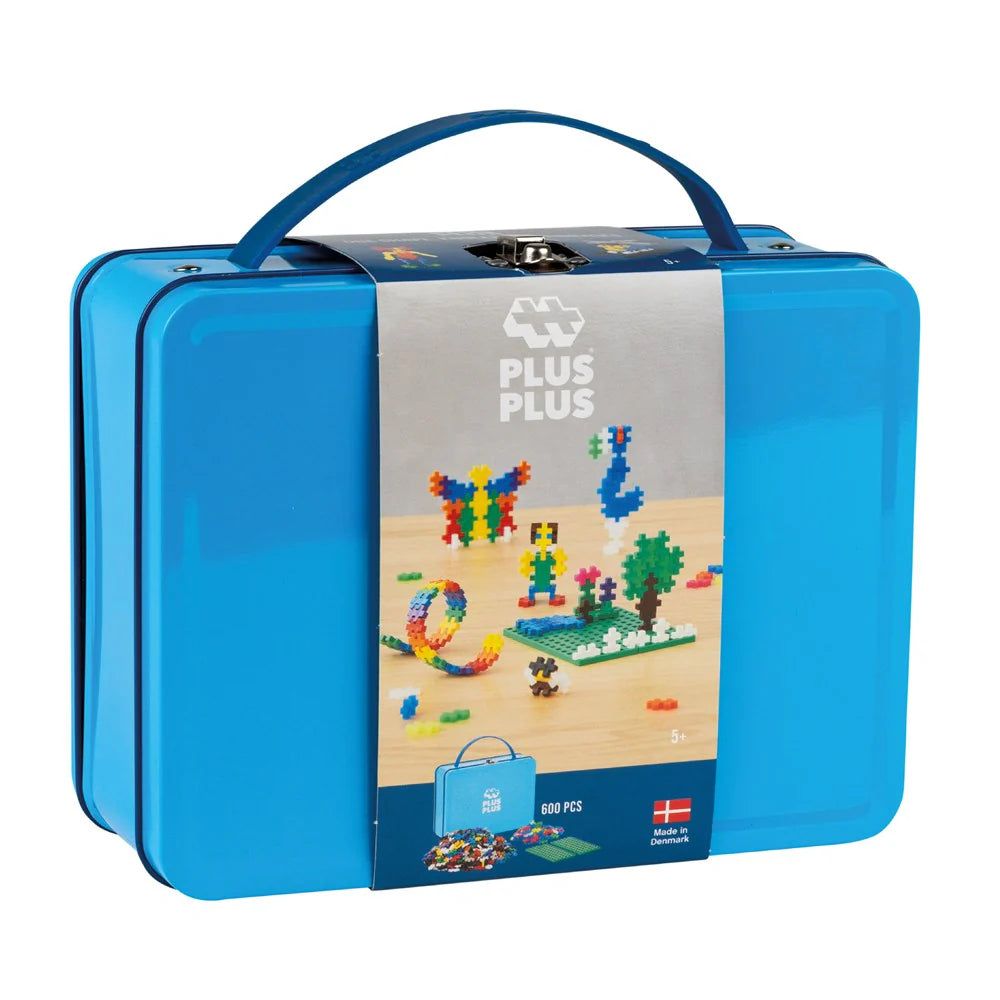 A blue metal suitcase with a construction toy set displayed on the front, labeled Plus-Plus with 600 pieces.