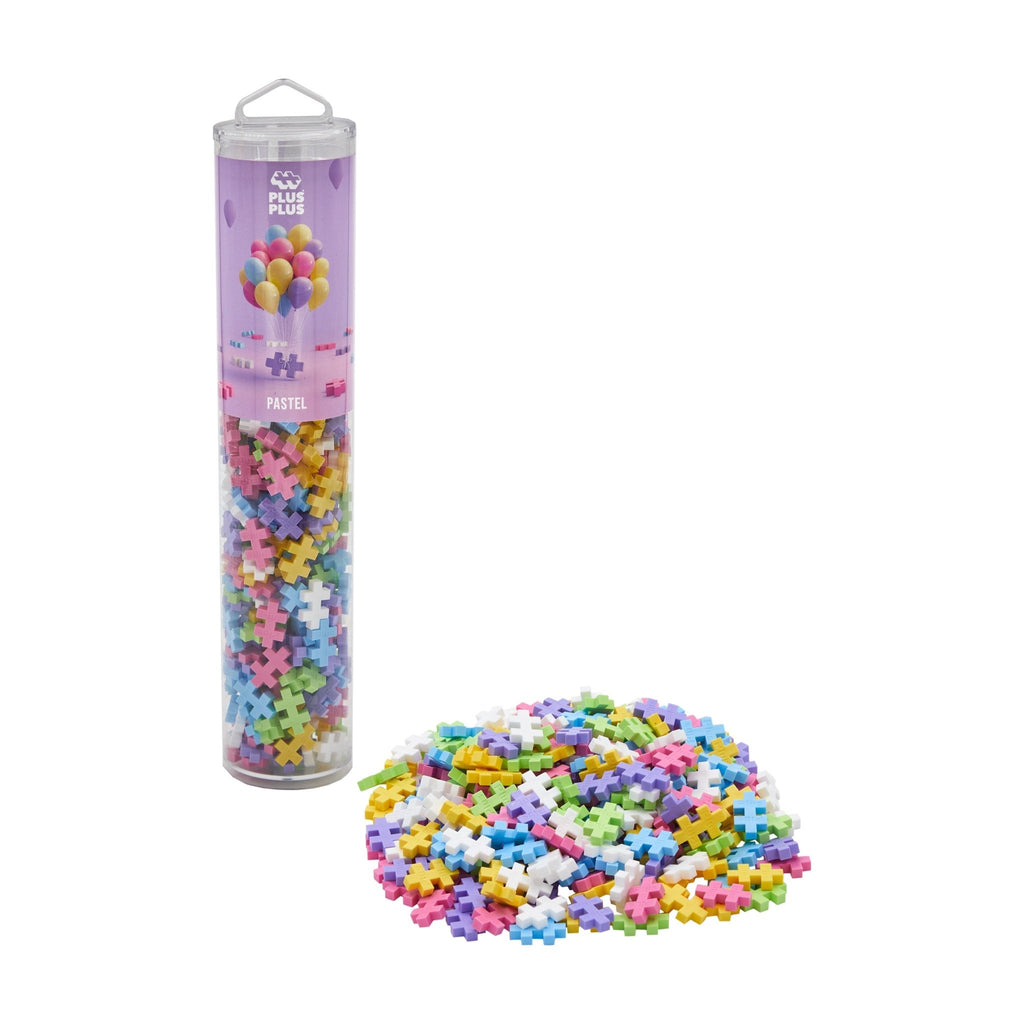 A tube container with colorful interlocking blocks spilled out in front, indicating a construction toy like Plus-Plus.