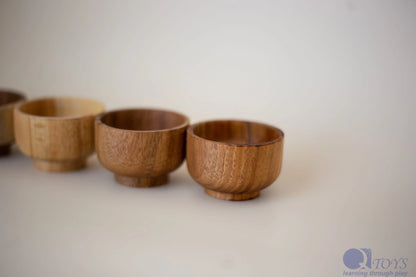 Line of wooden bowls on a plain background
