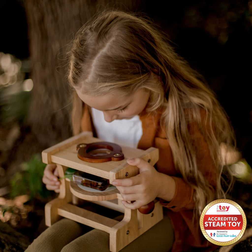 Child playing with a wooden toy outdoors