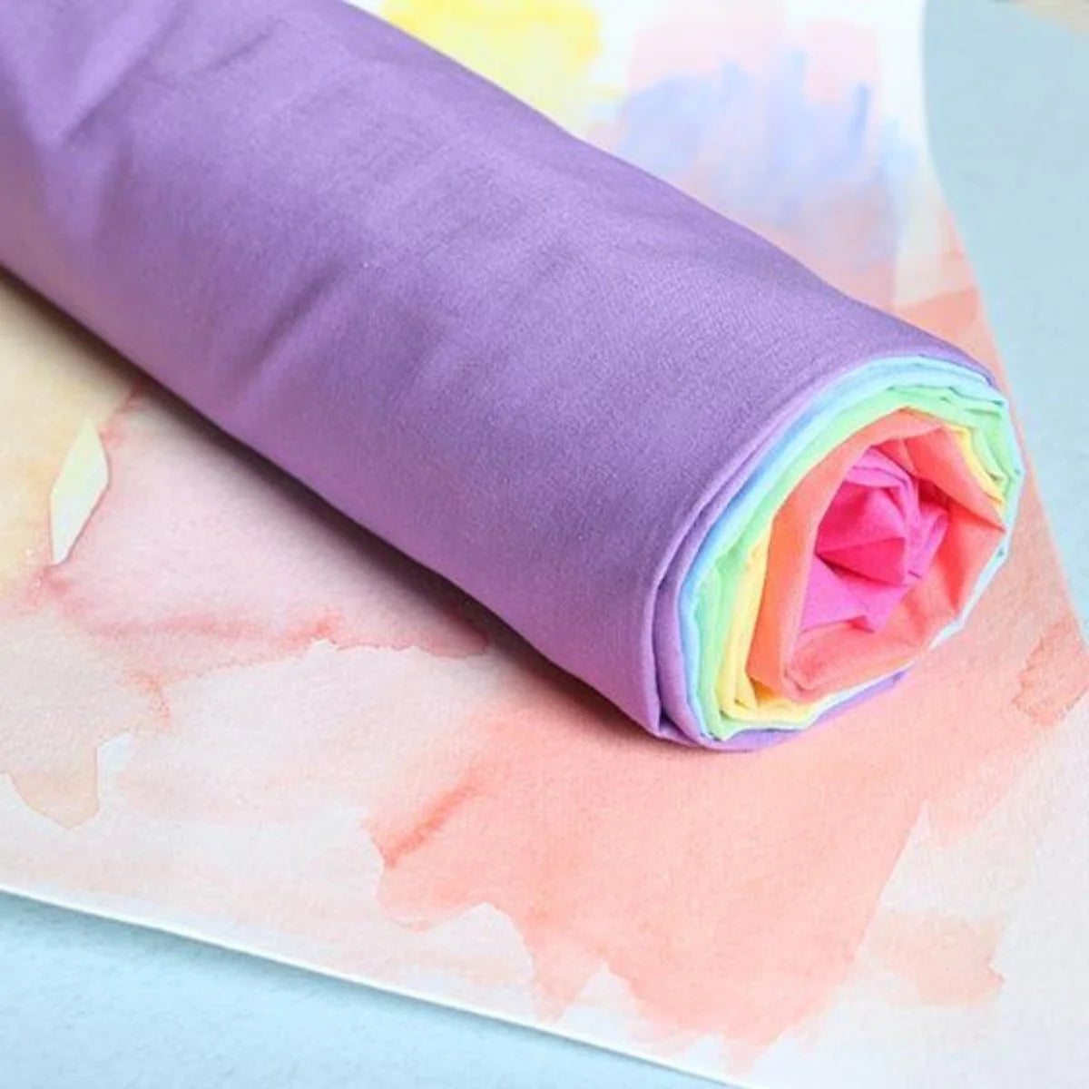 Roll of colorful fabric with a watercolor background