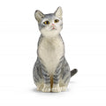 Cat figurine with gray and white pattern on a white background