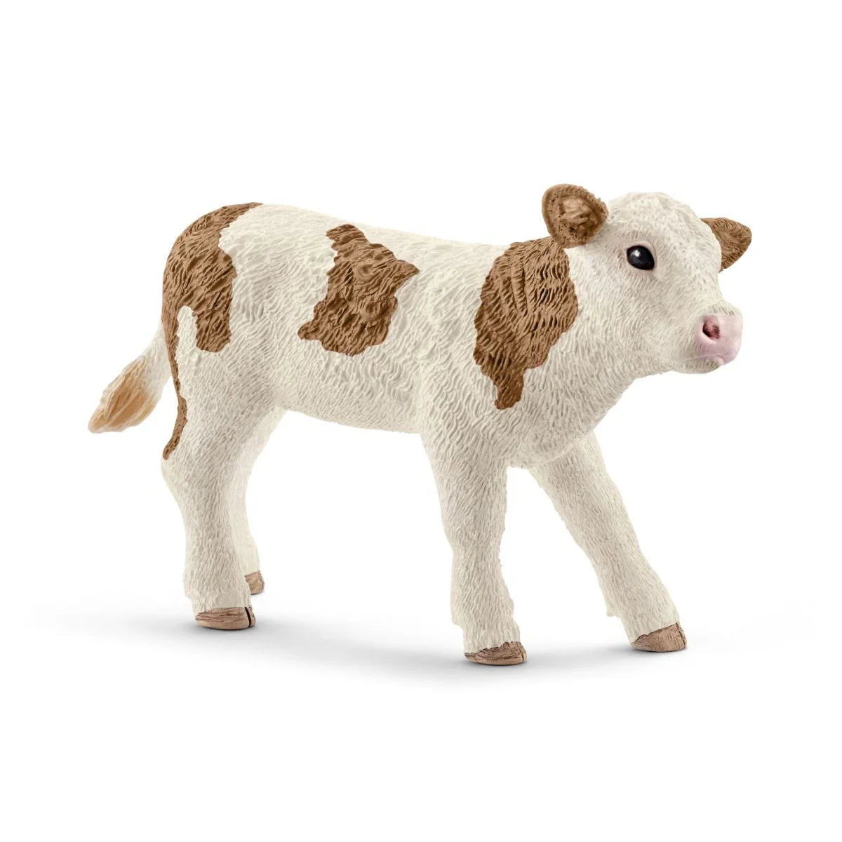 Toy cow figure with brown patches on a white background