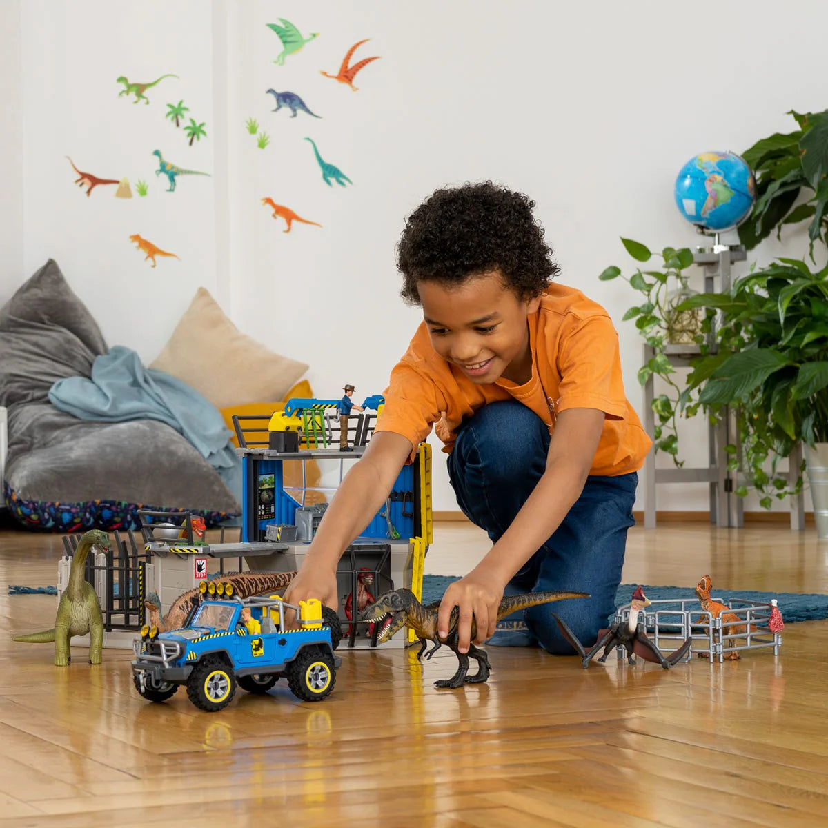 Child playing with toy cars and dinosaurs in a room with dinosaur wall decals.