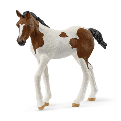 Model horse with brown and white pattern on a white background