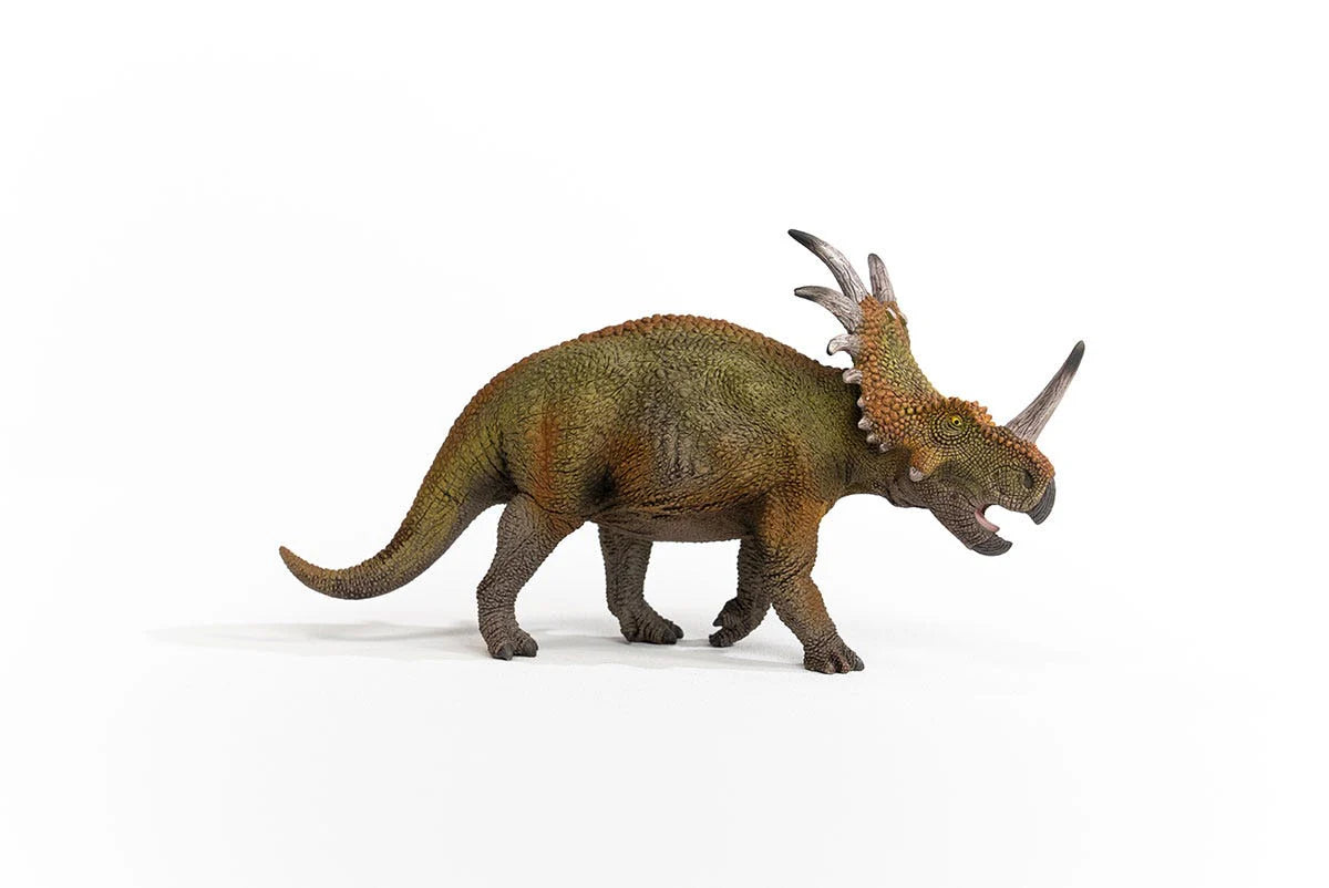 Dinosaur model with frill and horns on a white background