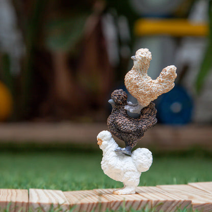 Two ceramic rooster figurines on a wooden platform with a blurred outdoor background
