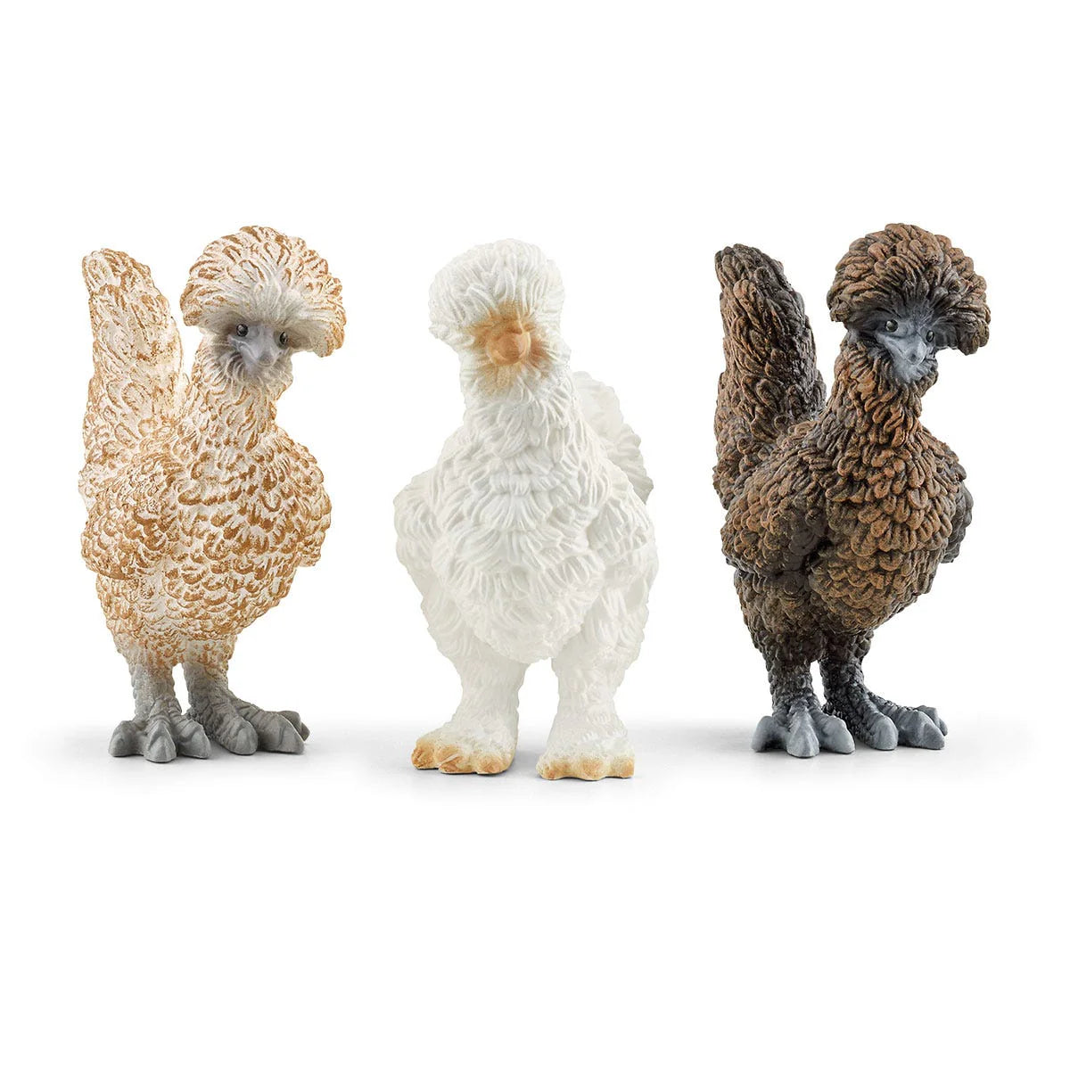 Three chicken figurines in different colors on a white background