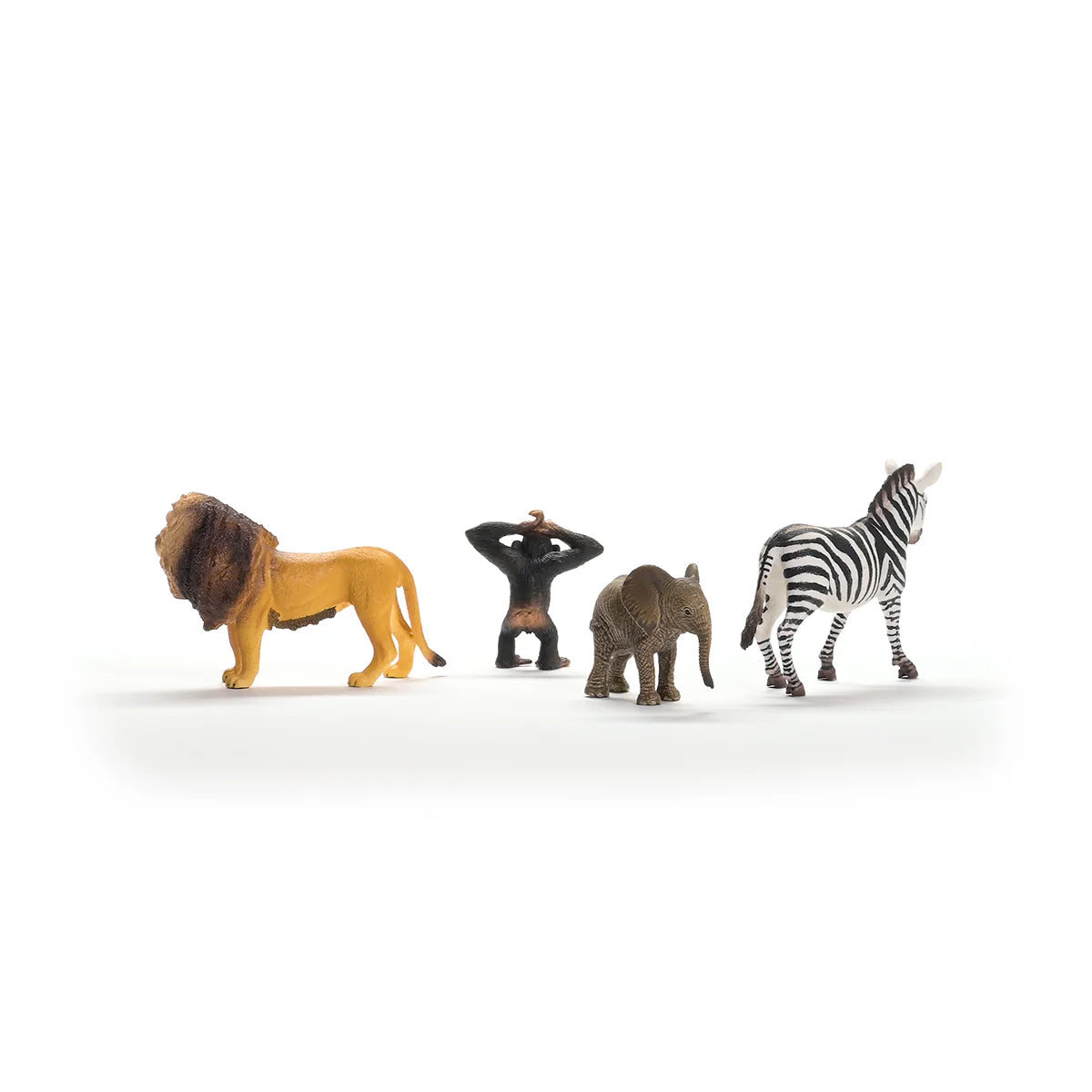 Toy figures of a lion, monkey, elephant, and zebra on a white background