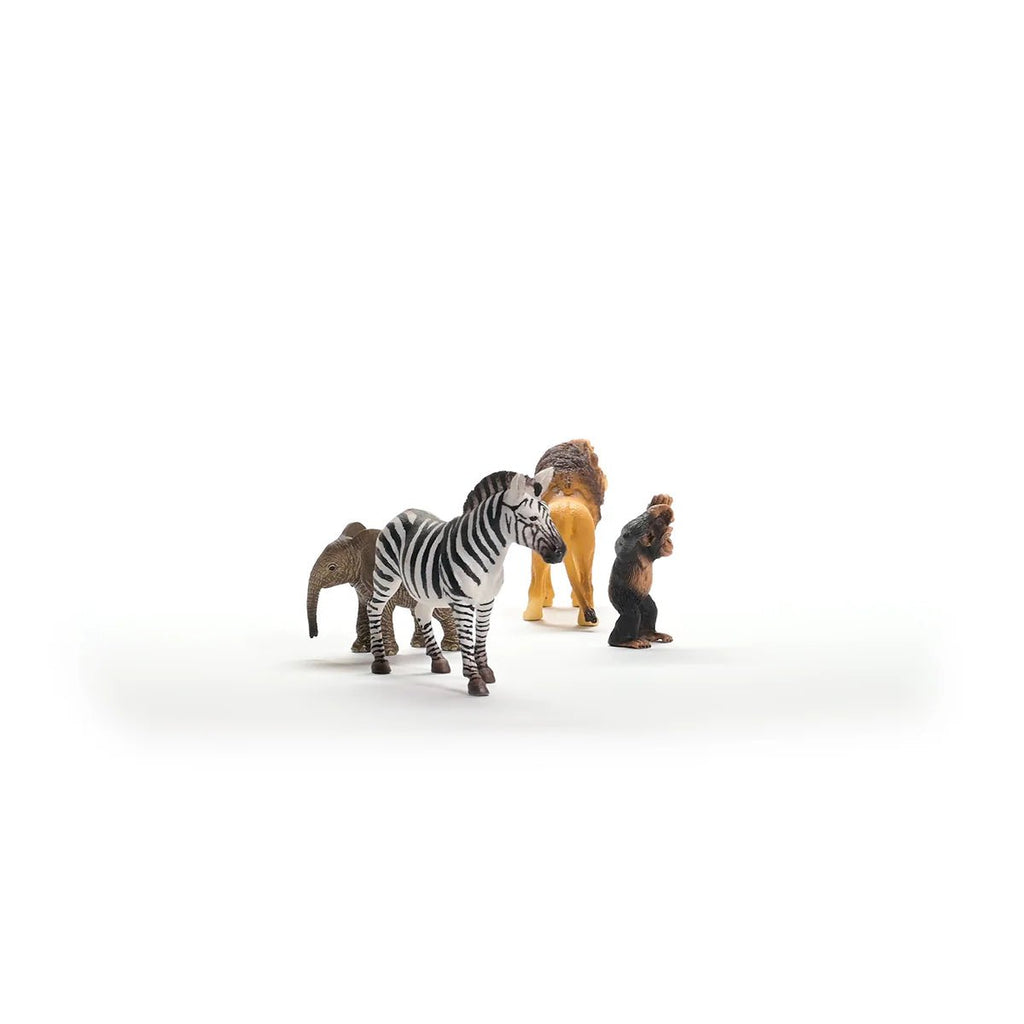 Toy figures of a zebra, lion, and monkey on a white background